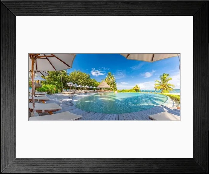Framed Print : Summer outdoor tourism landscape. Luxurious beach resort with swimming pool and beach chairs or loungers under umbrellas with palm trees and blue sky Framed Print : Summer outdoor tourism landscape. Luxurious beach resort with swimming pool and beach chairs or loungers under umbrellas with palm trees and blue sky