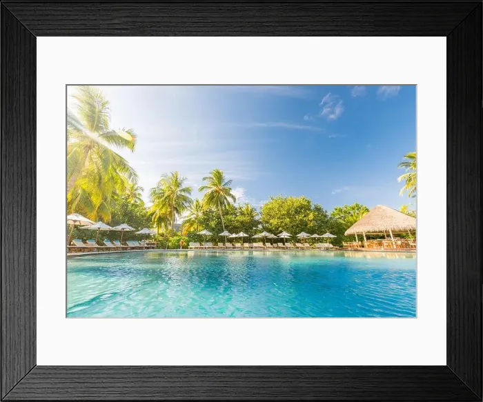 Framed Print : Summer outdoor tourism landscape. Luxurious beach resort with swimming pool and beach chairs or loungers under umbrellas with palm trees and blue sky Framed Print : Summer outdoor tourism landscape. Luxurious beach resort with swimming pool and beach chairs or loungers under umbrellas with palm trees and blue sky