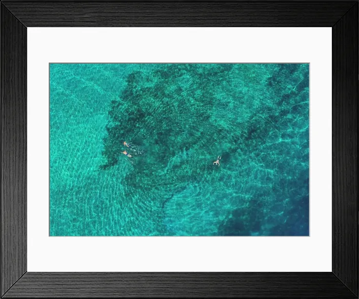 Framed Print : Father and son snorkels through tropical, turquoise waters, aerial view Framed Print : Father and son snorkels through tropical, turquoise waters, aerial view