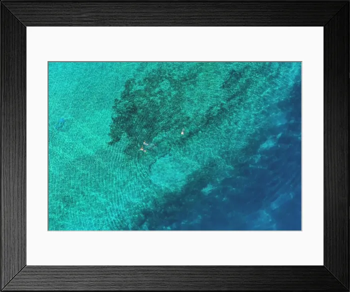 Framed Print : Father and son snorkels through tropical, turquoise waters, aerial view Framed Print : Father and son snorkels through tropical, turquoise waters, aerial view