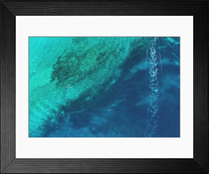 Framed Print : Father and son snorkels through tropical, turquoise waters, aerial view Framed Print : Father and son snorkels through tropical, turquoise waters, aerial view