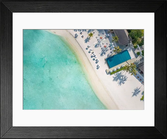 Framed Print : Outdoor tourism landscape. Luxurious beach resort with swimming pool and beach chairs or loungers under umbrellas with palm trees and blue sky. Exotic Framed Print : Outdoor tourism landscape. Luxurious beach resort with swimming pool and beach chairs or loungers under umbrellas with palm trees and blue sky. Exotic