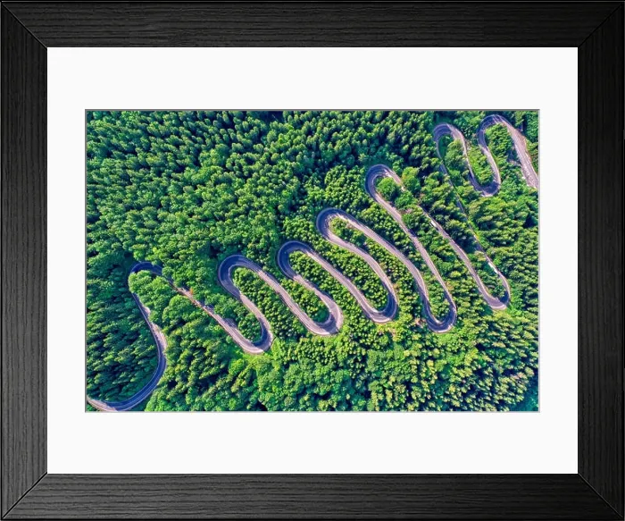 Framed Print : Aerial view of a winding mountain road passing through a fir trees forest Framed Print : Aerial view of a winding mountain road passing through a fir trees forest