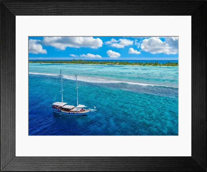 Framed Print : Small yacht sailing in tropical sea over coral reef in Indian ocean lagoon. Exotic island landscape, aerial view, tranquil nature scenic Framed Print : Small yacht sailing in tropical sea over coral reef in Indian ocean lagoon. Exotic island landscape, aerial view, tranquil nature scenic