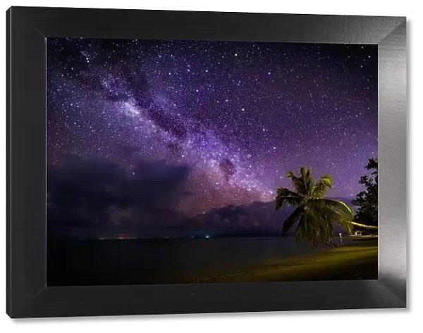 Amazing night photo with milky way, stars and bright galaxy view pattern. Milky Way over the sandy beach with palm trees