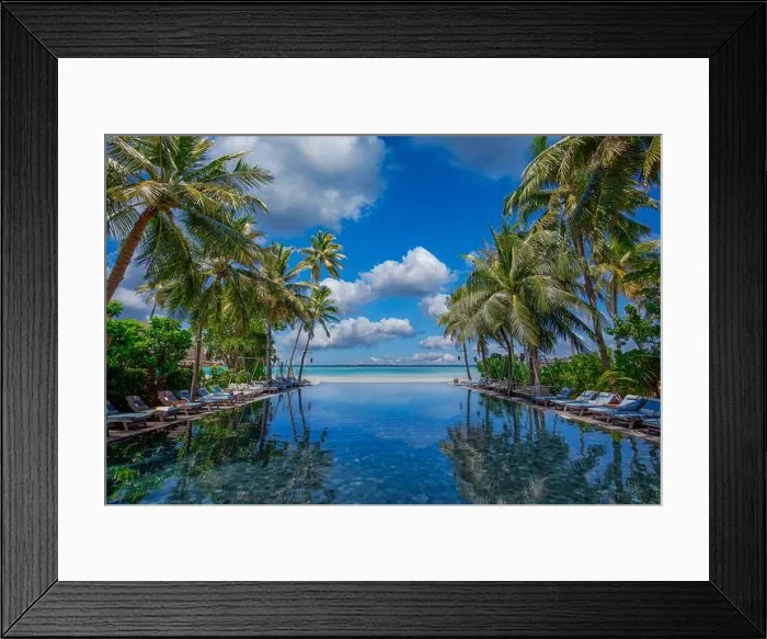 Framed Print : Luxury swimming pool in the tropical hotel or resort. Palm trees and infinity pool close to lounge chairs and umbrellas. Exotic travel destination Framed Print : Luxury swimming pool in the tropical hotel or resort. Palm trees and infinity pool close to lounge chairs and umbrellas. Exotic travel destination
