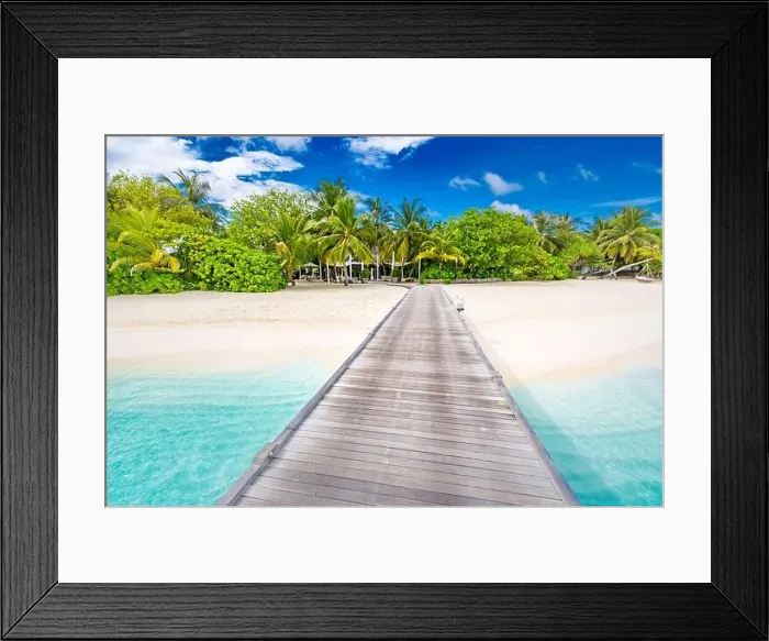 Framed Print : Beach with jetty on a tropical island. Maldives luxury paradise landscape. White sand over blue lagoon into palm tree covered island. Exotic travel Framed Print : Beach with jetty on a tropical island. Maldives luxury paradise landscape. White sand over blue lagoon into palm tree covered island. Exotic travel