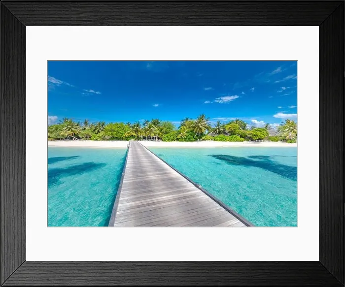 Framed Print : Beach with jetty on a tropical island. Maldives luxury paradise landscape. White sand over blue lagoon into palm tree covered island. Exotic travel Framed Print : Beach with jetty on a tropical island. Maldives luxury paradise landscape. White sand over blue lagoon into palm tree covered island. Exotic travel