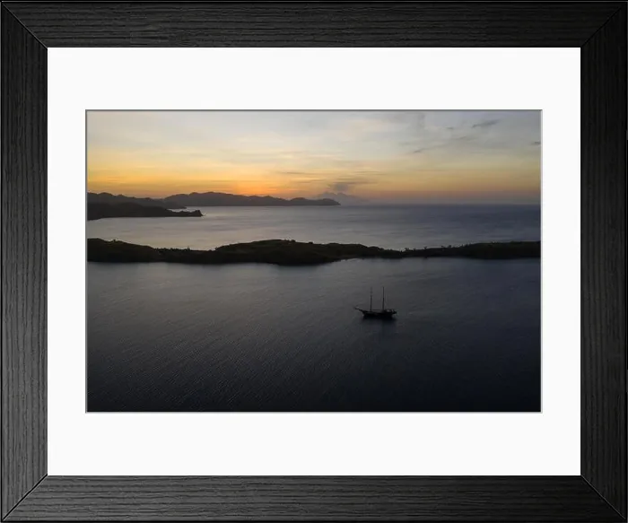 Framed Print : A traditional Pinisi schooner sails at sunset in Komodo National Park, Indonesia. This tropical area is known for its marine biodiversity