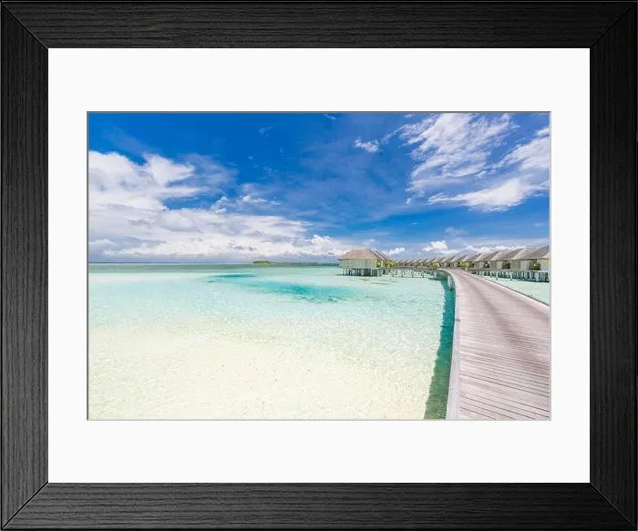 Framed Print : Tropical paradise: view of over water bungalows at a resort in the Maldives, Indian Ocean. Long jetty leading into water villas under blue tropic sky Framed Print : Tropical paradise: view of over water bungalows at a resort in the Maldives, Indian Ocean. Long jetty leading into water villas under blue tropic sky