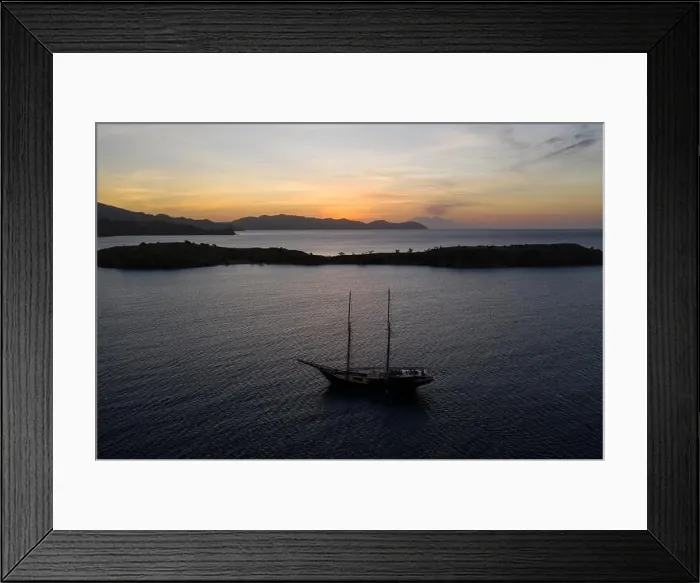 Framed Print : A traditional Pinisi schooner sails at sunset in Komodo National Park, Indonesia. This tropical area is known for its marine biodiversity