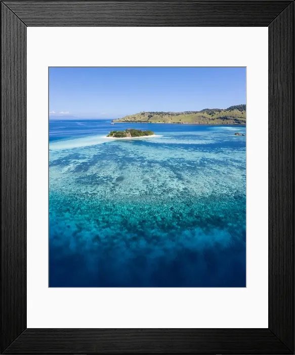 Framed Print : Seen from a bird's eye view, an idyllic tropical island is surrounded by a healthy coral reef in Komodo National Park, Indonesia