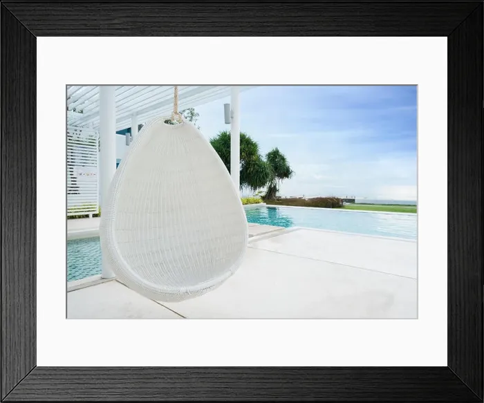 Framed Print : Relaxing white rattan hanging chair at swimming pool on sea view for vacation, summer and travel concept Framed Print : Relaxing white rattan hanging chair at swimming pool on sea view for vacation, summer and travel concept
