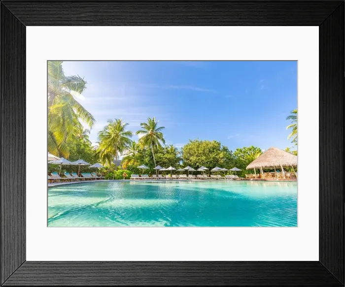 Framed Print : Outdoor summer tourism landscape. Luxurious beach resort with swimming pool and beach chairs or loungers under umbrellas with palm trees and blue sky Framed Print : Outdoor summer tourism landscape. Luxurious beach resort with swimming pool and beach chairs or loungers under umbrellas with palm trees and blue sky