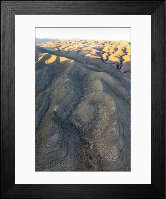 Framed Print : An aerial view shows the rugged, eroded desert landscape that surrounds Las Vegas, Nevada. This desert area averages over 95 degrees F during summer Framed Print : An aerial view shows the rugged, eroded desert landscape that surrounds Las Vegas, Nevada. This desert area averages over 95 degrees F during summer