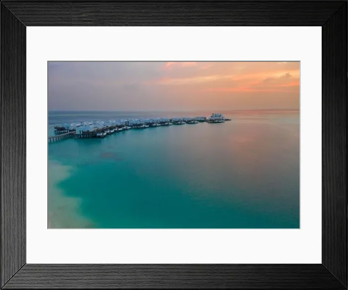 Framed Print : Aerial Maldives island sunset. Water bungalows resort at islands beach. Aerial Maldives. Beautiful sunset landscape, luxury resort and colorful sky Framed Print : Aerial Maldives island sunset. Water bungalows resort at islands beach. Aerial Maldives. Beautiful sunset landscape, luxury resort and colorful sky