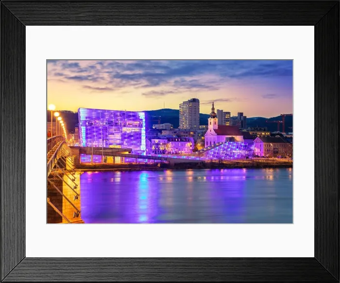 Framed Print : Linz, Austria. Cityscape image of riverside Linz, Austria during twilight blue hour with reflection of the city lights in Danube river Framed Print : Linz, Austria. Cityscape image of riverside Linz, Austria during twilight blue hour with reflection of the city lights in Danube river