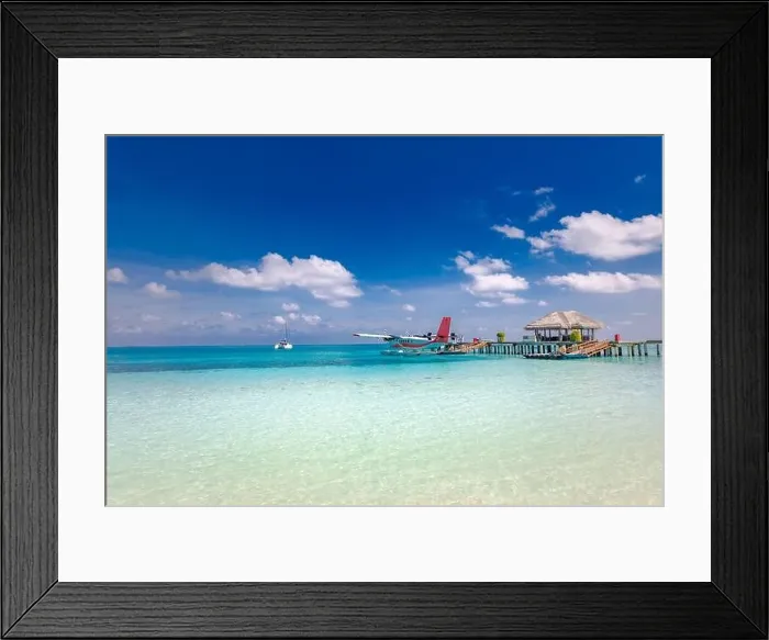 Framed Print : Maldives background concept. Traditional boat Dhoni, wooden jetty tropical island and beach. Summer vacation and luxury travel concept, seaplane Framed Print : Maldives background concept. Traditional boat Dhoni, wooden jetty tropical island and beach. Summer vacation and luxury travel concept, seaplane