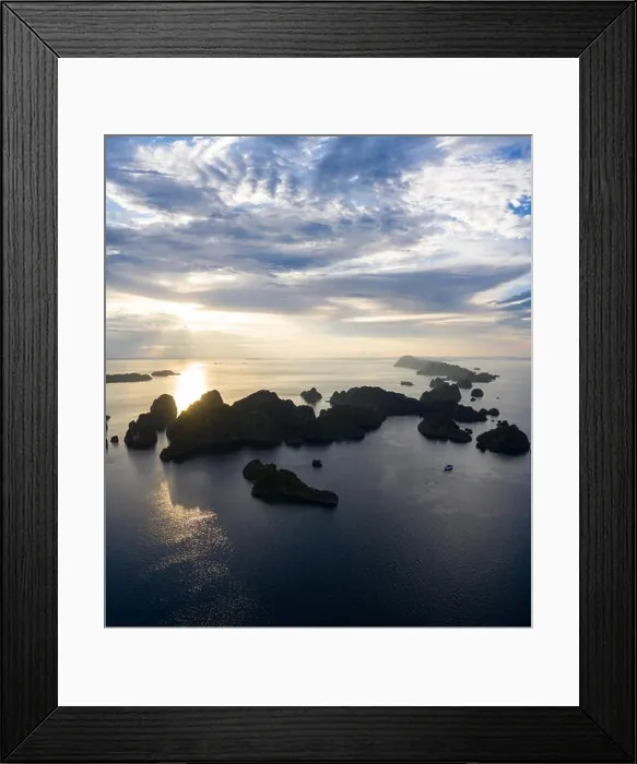 Framed Print : Limestone islands, surrounded by coral reefs, lie scattered throughout the Raja Ampat seascape. This region is known for its marine biodiversity Framed Print : Limestone islands, surrounded by coral reefs, lie scattered throughout the Raja Ampat seascape. This region is known for its marine biodiversity