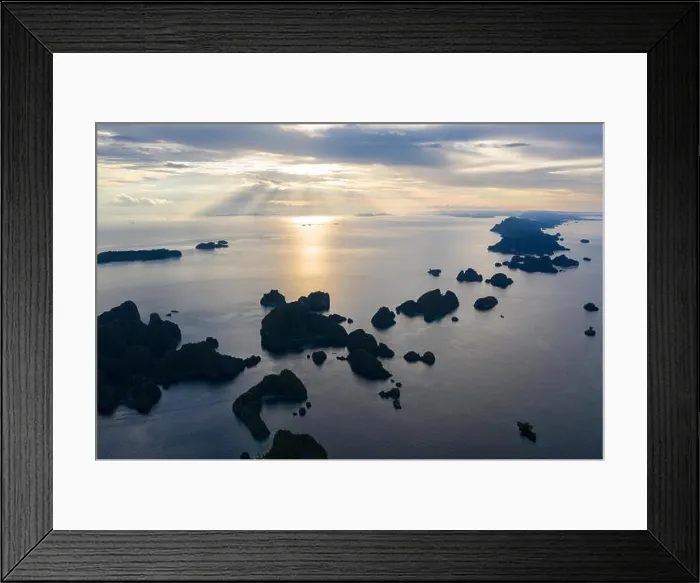 Framed Print : Limestone islands, surrounded by coral reefs, lie scattered throughout the Raja Ampat seascape. This region is known for its marine biodiversity Framed Print : Limestone islands, surrounded by coral reefs, lie scattered throughout the Raja Ampat seascape. This region is known for its marine biodiversity