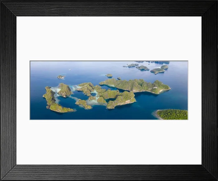 Framed Print : Limestone islands, surrounded by coral reefs, lie scattered throughout the Raja Ampat seascape. This region is known for its marine biodiversity Framed Print : Limestone islands, surrounded by coral reefs, lie scattered throughout the Raja Ampat seascape. This region is known for its marine biodiversity
