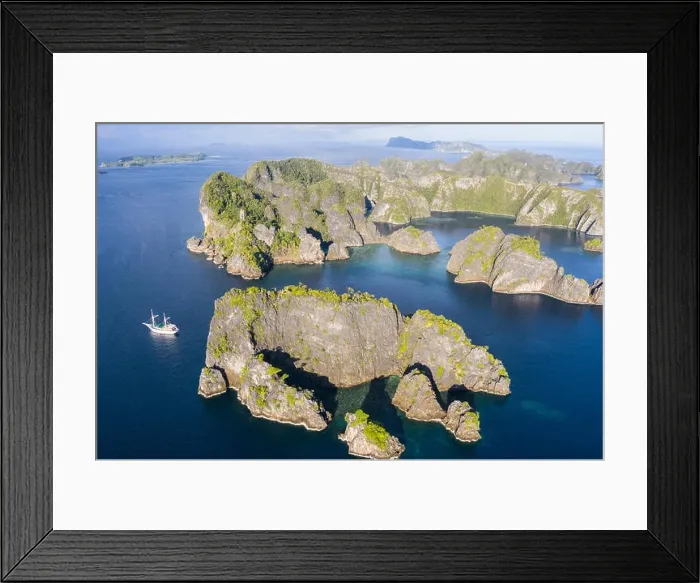Framed Print : A bird's eye view shows healthy reefs surrounding remote limestone islands in Raja Ampat. This area is known for its incredible marine biodiversity Framed Print : A bird's eye view shows healthy reefs surrounding remote limestone islands in Raja Ampat. This area is known for its incredible marine biodiversity