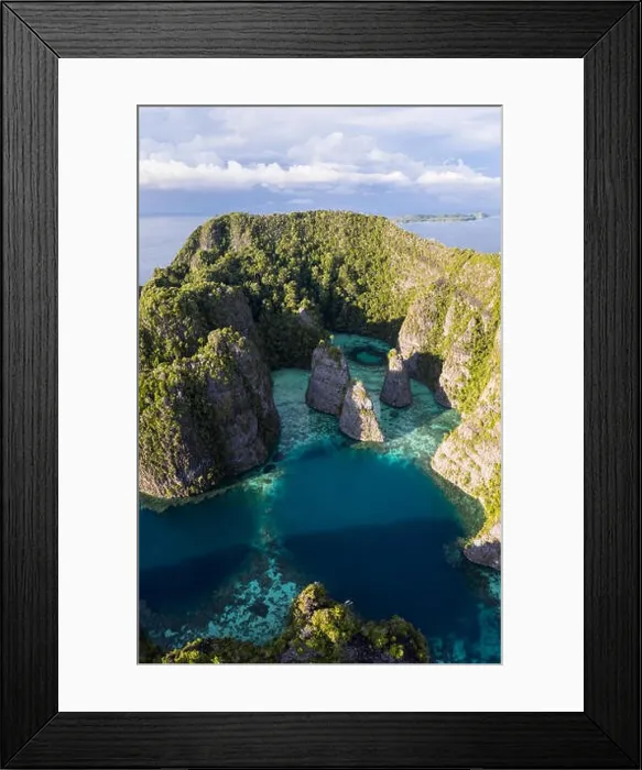 Framed Print : A bird's eye view shows healthy reefs surrounding remote limestone islands in Raja Ampat. This area is known for its incredible marine biodiversity Framed Print : A bird's eye view shows healthy reefs surrounding remote limestone islands in Raja Ampat. This area is known for its incredible marine biodiversity