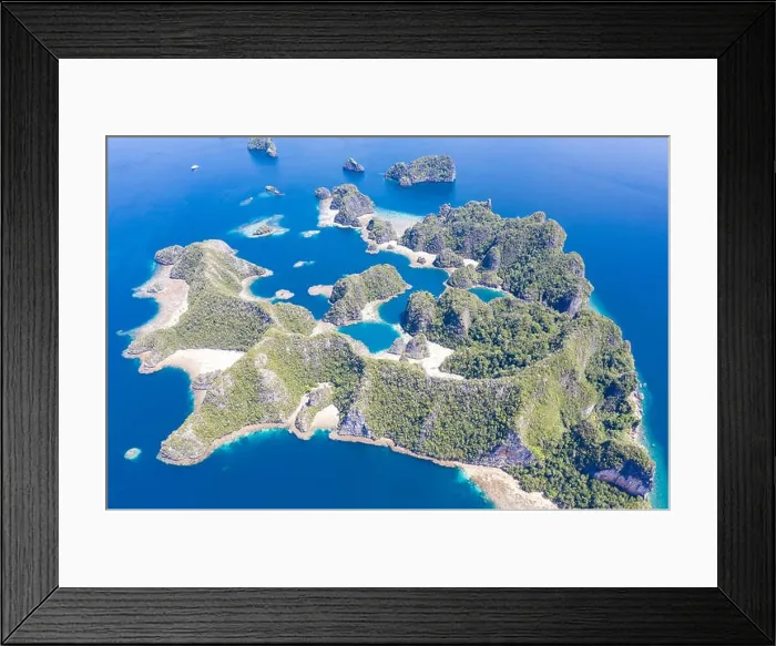 Framed Print : A bird's eye view shows healthy reefs surrounding remote limestone islands in Raja Ampat. This area is known for its incredible marine biodiversity Framed Print : A bird's eye view shows healthy reefs surrounding remote limestone islands in Raja Ampat. This area is known for its incredible marine biodiversity