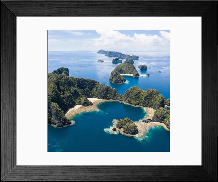 Framed Print : A bird's eye view shows healthy reefs surrounding remote limestone islands in Raja Ampat. This area is known for its incredible marine biodiversity Framed Print : A bird's eye view shows healthy reefs surrounding remote limestone islands in Raja Ampat. This area is known for its incredible marine biodiversity