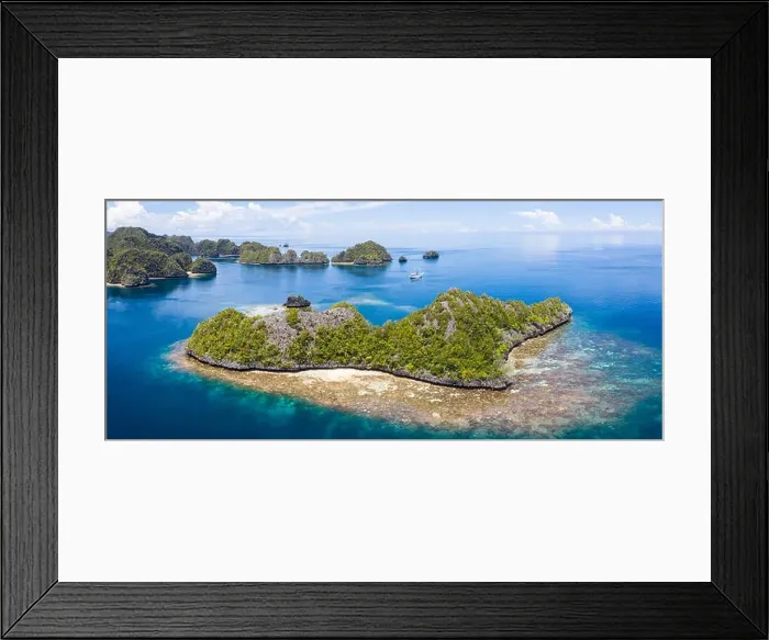 Framed Print : A bird's eye view shows healthy reefs surrounding remote limestone islands in Raja Ampat. This area is known for its incredible marine biodiversity Framed Print : A bird's eye view shows healthy reefs surrounding remote limestone islands in Raja Ampat. This area is known for its incredible marine biodiversity