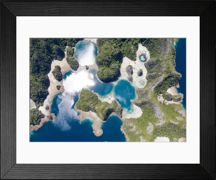 Framed Print : A bird's eye view shows healthy reefs surrounding remote limestone islands in Raja Ampat. This area is known for its incredible marine biodiversity Framed Print : A bird's eye view shows healthy reefs surrounding remote limestone islands in Raja Ampat. This area is known for its incredible marine biodiversity