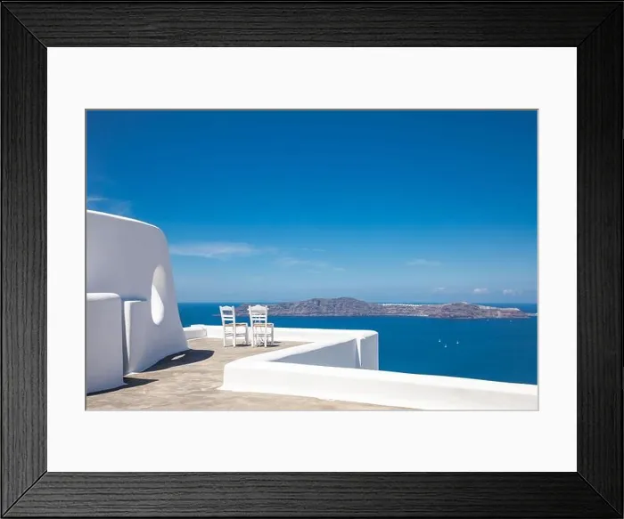 Framed Print : Two chairs on the terrace with sea view. White architecture on Santorini island, Greece. Travel destinations concept, summer holiday, luxury landscape Framed Print : Two chairs on the terrace with sea view. White architecture on Santorini island, Greece. Travel destinations concept, summer holiday, luxury landscape