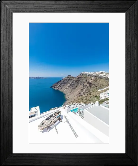 Framed Print : Scenic view of traditional cycladic resort with decoration boat foreground, Oia village, Santorini, Greece. Famous travel destination, luxury holiday Framed Print : Scenic view of traditional cycladic resort with decoration boat foreground, Oia village, Santorini, Greece. Famous travel destination, luxury holiday