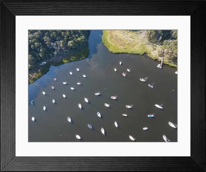 Framed Print : Dozens of sailboats are moored in a calm bay on Cape Cod, Massachusetts. This peninsula is a popular summer vacation destination in New England Framed Print : Dozens of sailboats are moored in a calm bay on Cape Cod, Massachusetts. This peninsula is a popular summer vacation destination in New England