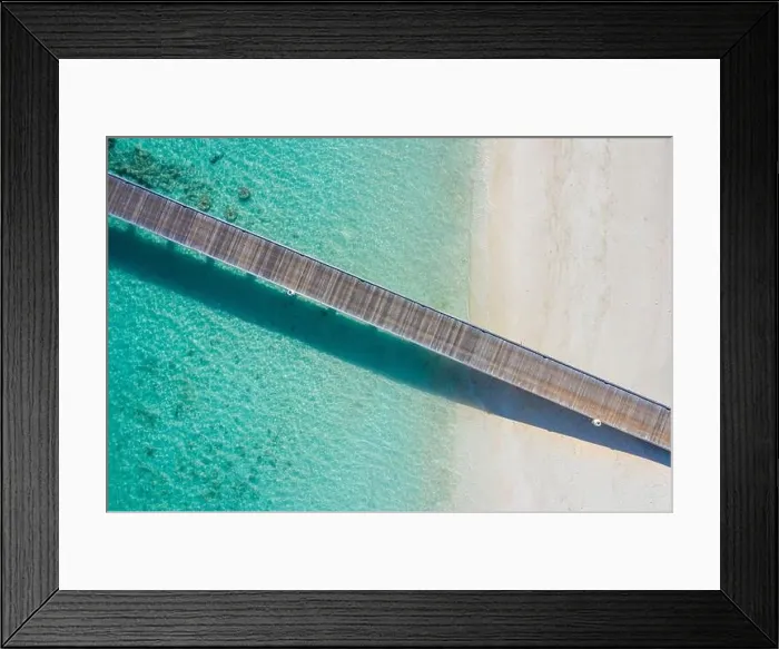 Framed Print : Exotic aerial view of turquoise water with wooden jetty on Maldives island, beautiful shallow sea water and corals with white sand. Motivational Framed Print : Exotic aerial view of turquoise water with wooden jetty on Maldives island, beautiful shallow sea water and corals with white sand. Motivational