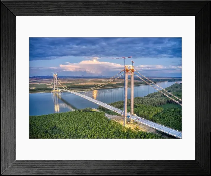Framed Print : Panoramic aerial drone view from above of the suspended bridge over danube river, under construction, between Braila and Tulcea cities in Romania