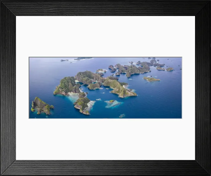Framed Print : Limestone islands lie scattered about the seascape in Raja Ampat, Indonesia. This remote, tropical region is known for its marine biodiversity Framed Print : Limestone islands lie scattered about the seascape in Raja Ampat, Indonesia. This remote, tropical region is known for its marine biodiversity