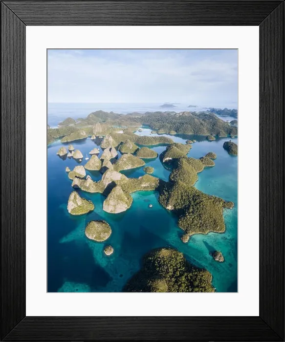 Framed Print : Remote limestone islands form a maze in a tropical lagoon in Raja Ampat, Indonesia. This diverse region is known as the heart of the Coral Triangle Framed Print : Remote limestone islands form a maze in a tropical lagoon in Raja Ampat, Indonesia. This diverse region is known as the heart of the Coral Triangle
