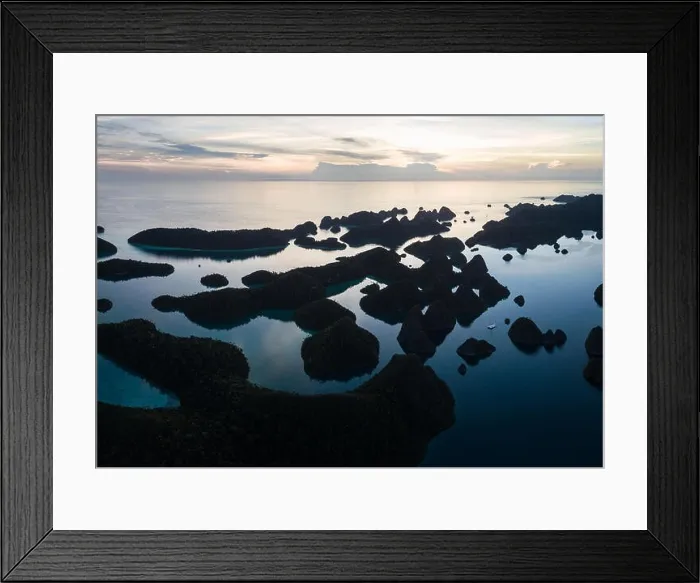 Framed Print : Remote limestone islands form a maze in a tropical lagoon in Raja Ampat, Indonesia. This diverse region is known as the heart of the Coral Triangle Framed Print : Remote limestone islands form a maze in a tropical lagoon in Raja Ampat, Indonesia. This diverse region is known as the heart of the Coral Triangle