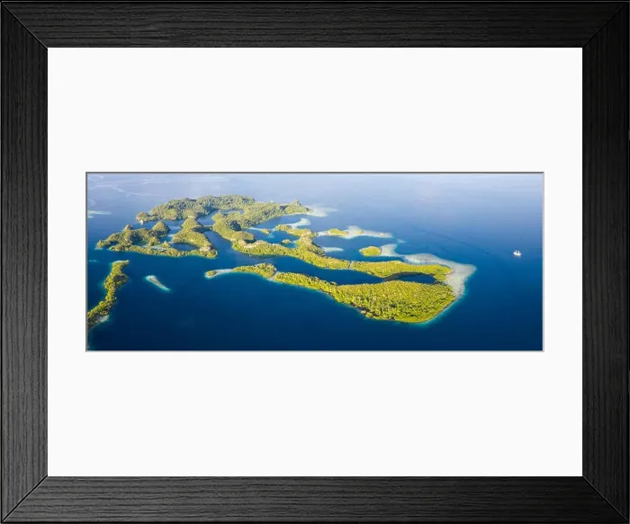 Framed Print : Remote limestone islands rise from the stunning seascape in Raja Ampat, Indonesia. This diverse region is known as the heart of the Coral Triangle