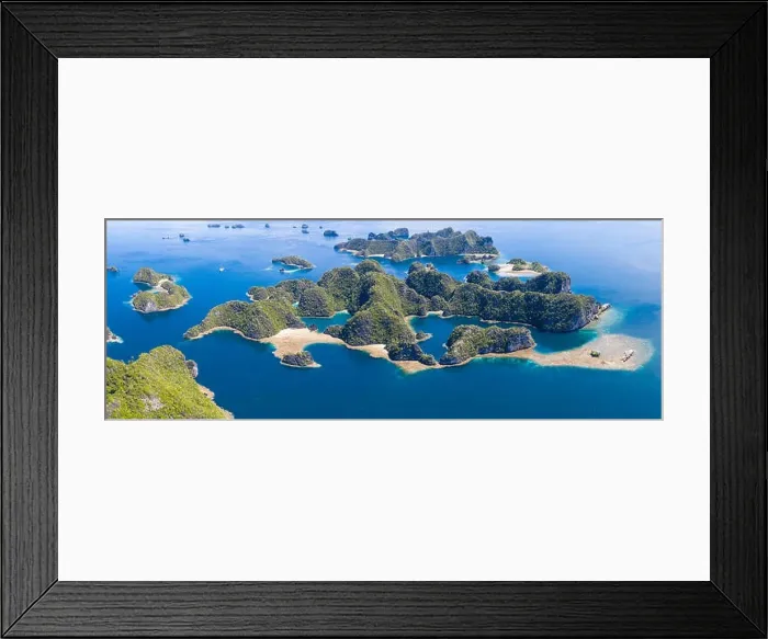Framed Print : Shallow coral reefs surround remote limestone islands in Raja Ampat, Indonesia. This biodiverse region is known as the heart of the Coral Triangle