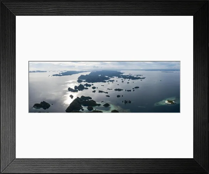 Framed Print : Seen from above, remote islands are surrounded by coral reefs in Raja Ampat, Indonesia. This region is known as the heart of the Coral Triangle Framed Print : Seen from above, remote islands are surrounded by coral reefs in Raja Ampat, Indonesia. This region is known as the heart of the Coral Triangle