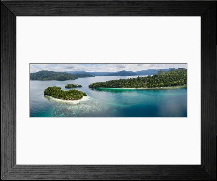 Framed Print : Seen from above, remote islands are surrounded by coral reefs in Raja Ampat, Indonesia. This region is known as the heart of the Coral Triangle Framed Print : Seen from above, remote islands are surrounded by coral reefs in Raja Ampat, Indonesia. This region is known as the heart of the Coral Triangle