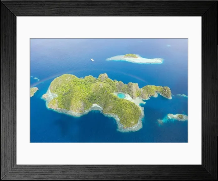 Framed Print : A faint rainbow curves over a scenic set of limestone islands in Raja Ampat, Indonesia. This remote region is known for its high marine biodiversity Framed Print : A faint rainbow curves over a scenic set of limestone islands in Raja Ampat, Indonesia. This remote region is known for its high marine biodiversity