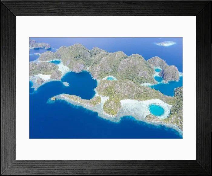 Framed Print : Warm seas surround rugged limestone islands in Raja Ampat, Indonesia. This area is known as the Coral Triangle due to its high marine biodiversity Framed Print : Warm seas surround rugged limestone islands in Raja Ampat, Indonesia. This area is known as the Coral Triangle due to its high marine biodiversity