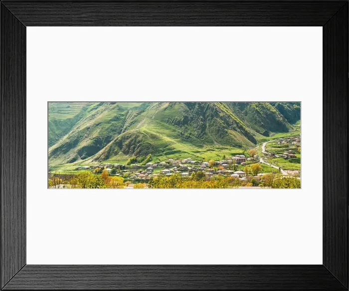 Framed Print : Stepantsminda Village At Evening In Kazbegi District, Mtskheta-Mtianeti Region, Georgia. Sunny Day At Spring Or Summer Season. Panorama Framed Print : Stepantsminda Village At Evening In Kazbegi District, Mtskheta-Mtianeti Region, Georgia. Sunny Day At Spring Or Summer Season. Panorama