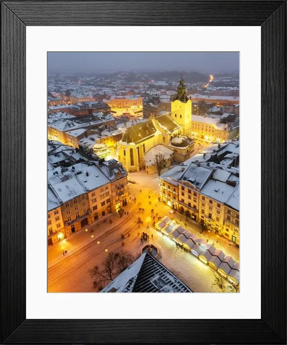 Framed Print : Gorgeus cityscape of winter Lviv city with roofs covered by snow from top of town hall, Ukraine, Europe. Latin Cathedral glowing by city lights Framed Print : Gorgeus cityscape of winter Lviv city with roofs covered by snow from top of town hall, Ukraine, Europe. Latin Cathedral glowing by city lights