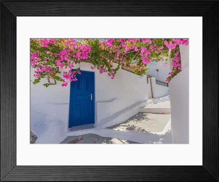 Framed Print : Romantic blue door with pink flowers, idyllic nature. Couple honeymoon destination, urban street banner. Santorini, Greece