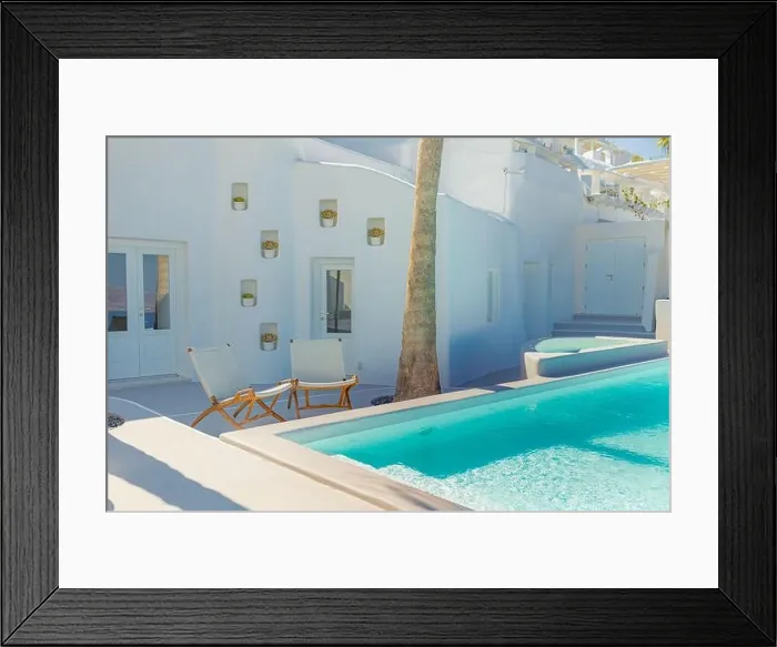 Framed Print : Santorini island, Greece. Luxury summer travel and vacation landscape. Swimming pool with white architecture, two chairs under palm tree. Greek style Framed Print : Santorini island, Greece. Luxury summer travel and vacation landscape. Swimming pool with white architecture, two chairs under palm tree. Greek style