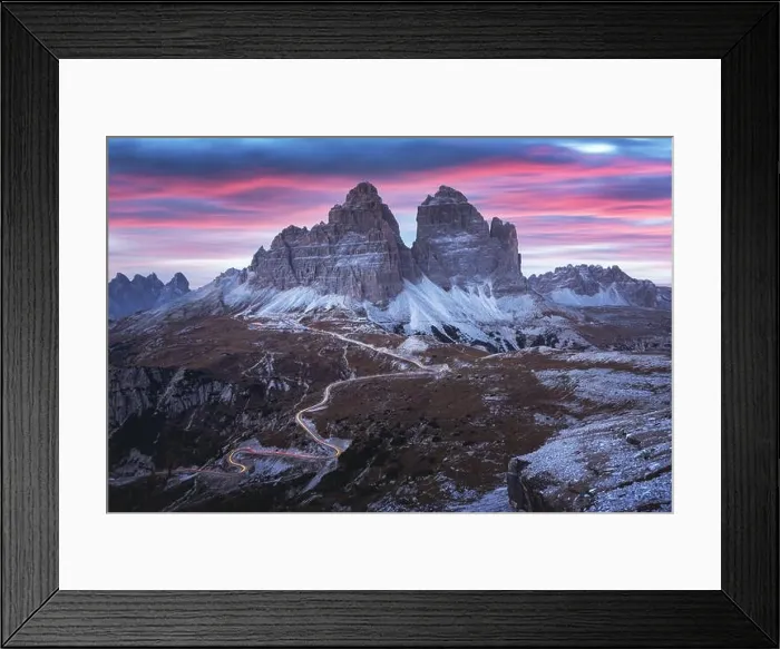 Framed Print : Dramatic evening landscape with Three peaks of Lavaredo mountains, glowing road and pink sunset sky Framed Print : Dramatic evening landscape with Three peaks of Lavaredo mountains, glowing road and pink sunset sky
